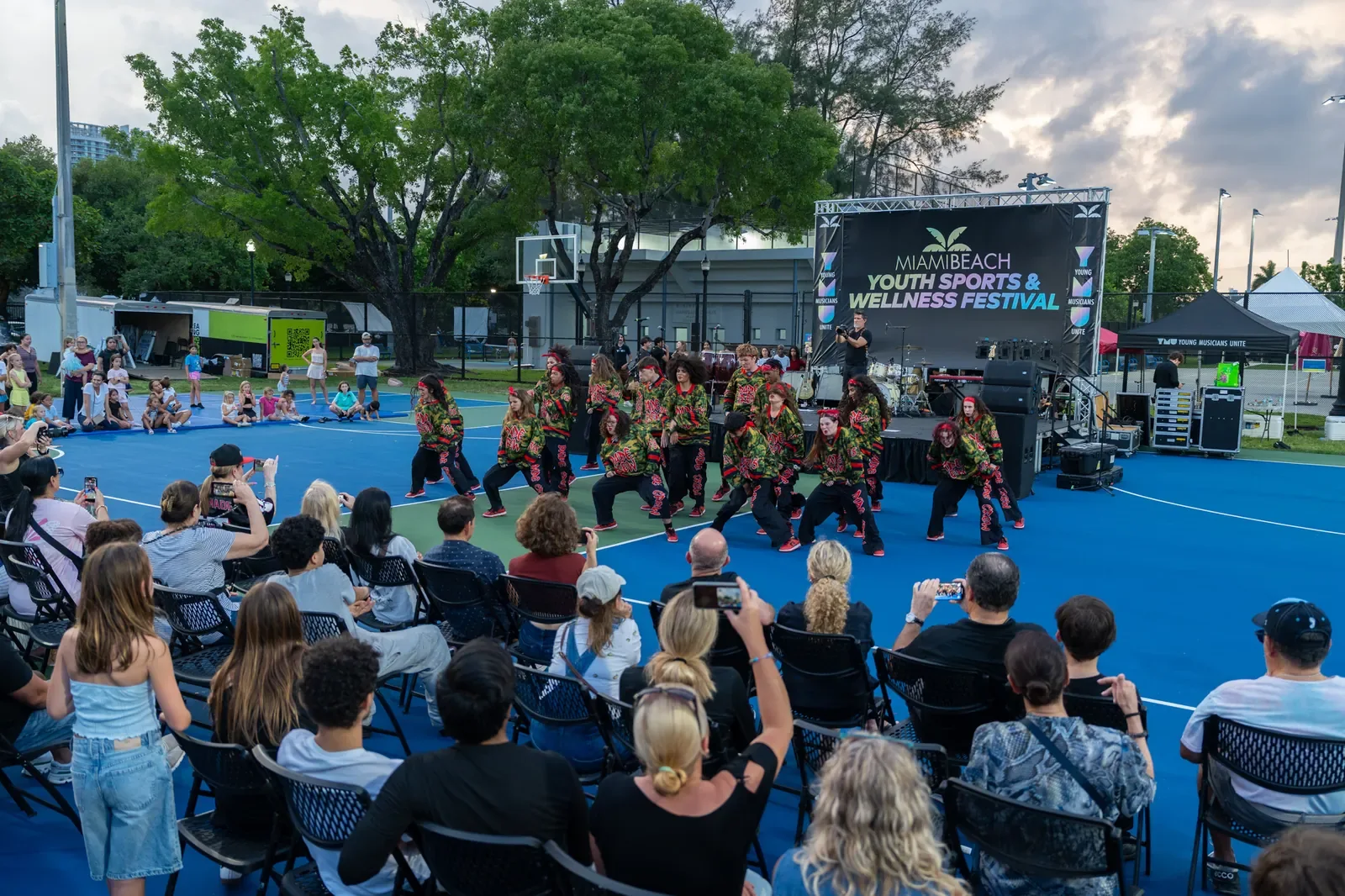 Families watching performers at the 2026 festival opening celebration in Flamingo Park