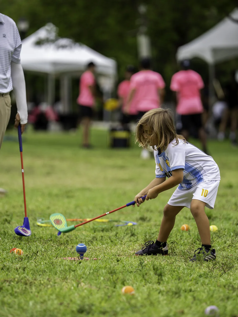 Child practicing a golf swing at a 2026 festival golf skills activation