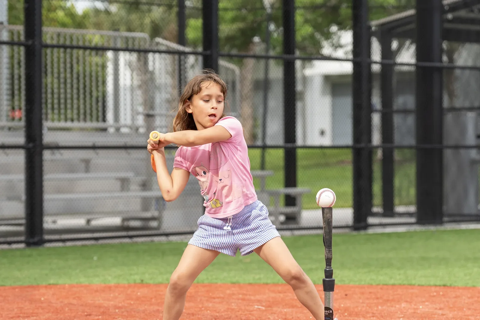 Girl taking her first swings at the festival softball activity