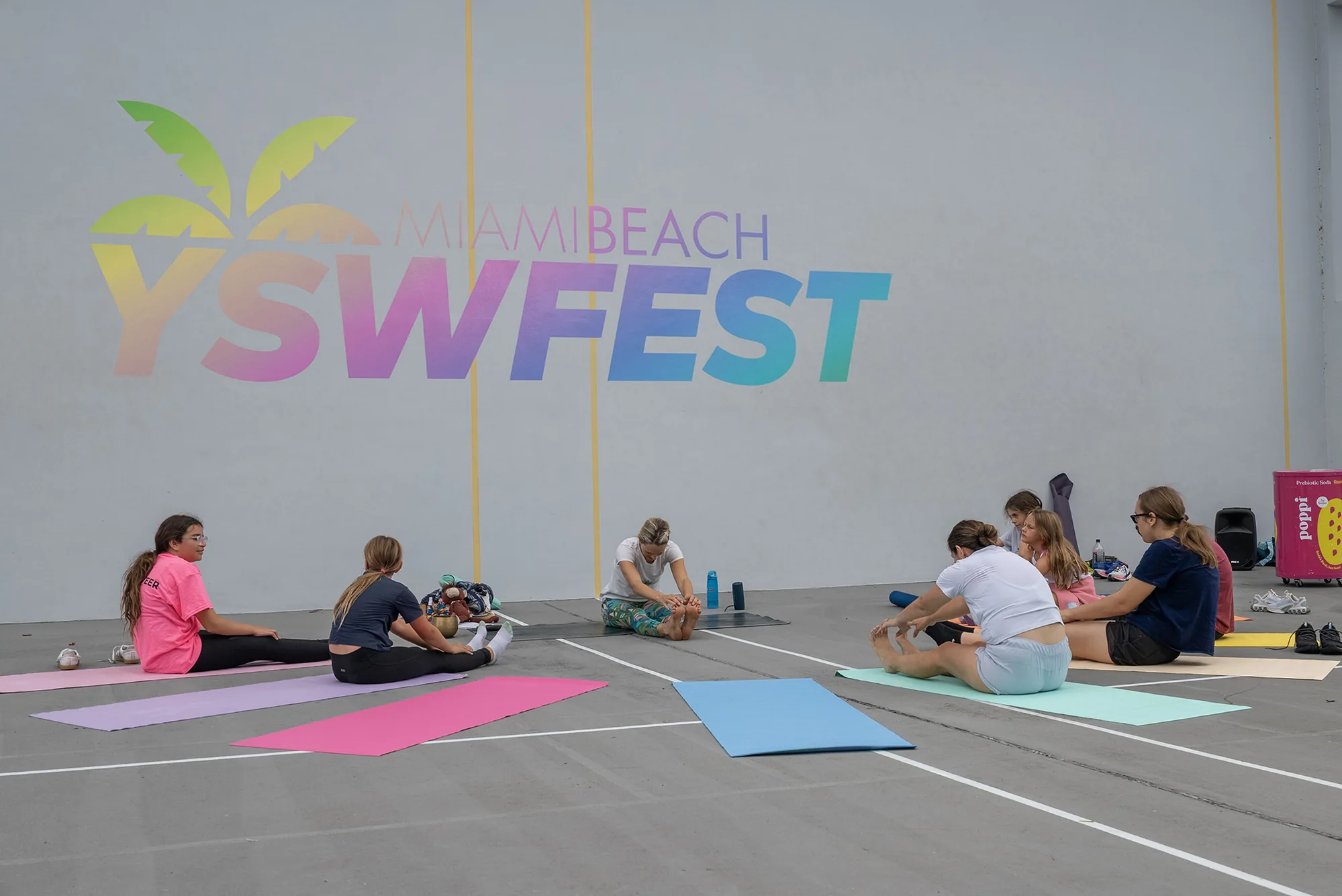 Group practicing yoga and wellness activities in front of a 2026 YSW Festival banner