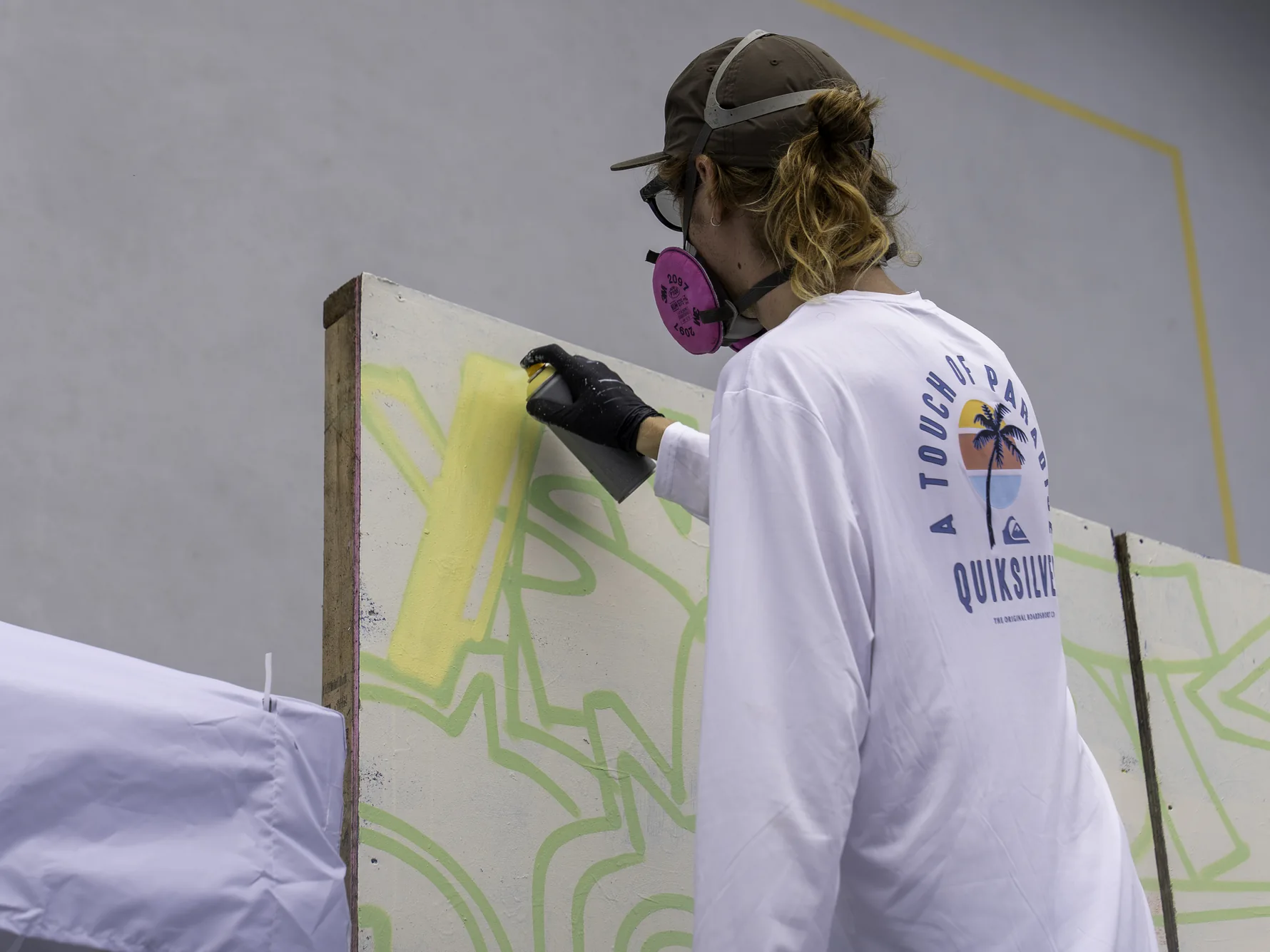 Person painting a large festival artwork during a creative activation in 2026